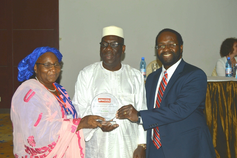  L'hon. Le ministre de l'Agriculture (milieu) présente une plaque au PDG du premier client de Sproxil Mali (à gauche) avec le soutien du PDG de Sproxil (à droite). 